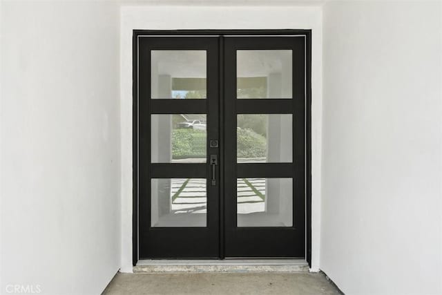 doorway to outside featuring concrete flooring and french doors