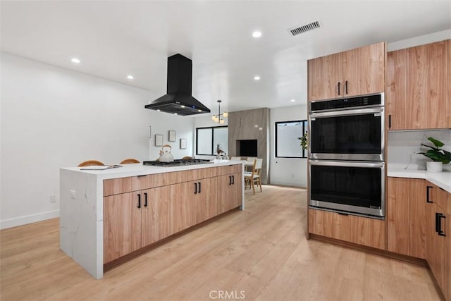 2037 Rayshire St, Thousand Oaks, CA 91362 - kitchen with island range hood, appliances with stainless steel finishes, a kitchen island, light wood-style floors, and light countertops