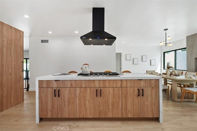 2037 Rayshire St, Thousand Oaks, CA 91362 - kitchen with island exhaust hood, stainless steel gas stovetop, light wood-type flooring, healthy amount of natural light, and recessed lighting