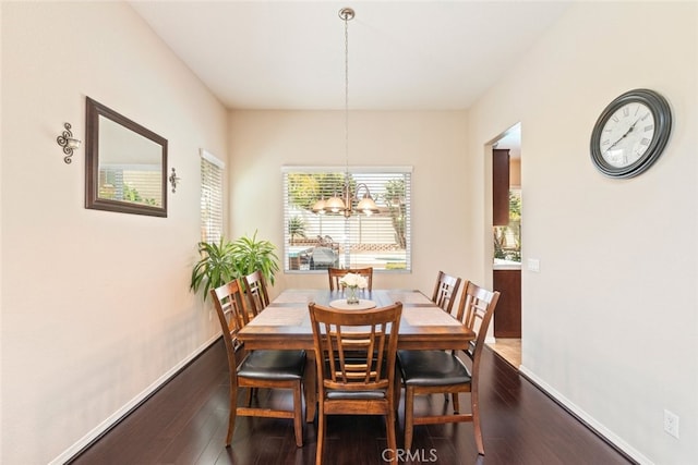 dining room with baseboards, an inviting chandelier, and wood finished floors