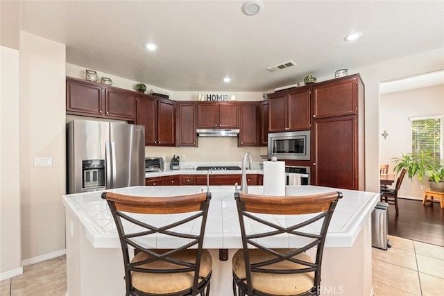 kitchen featuring recessed lighting, visible vents, appliances with stainless steel finishes, and tile counters