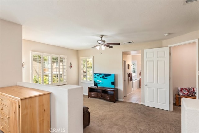 interior space with visible vents, ceiling fan, and carpet