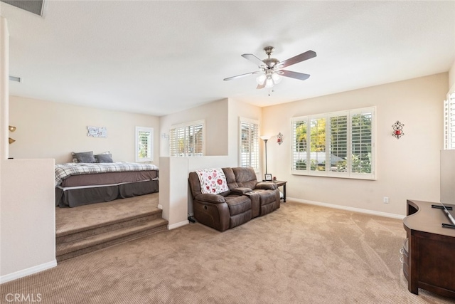 bedroom featuring visible vents, baseboards, multiple windows, and light colored carpet