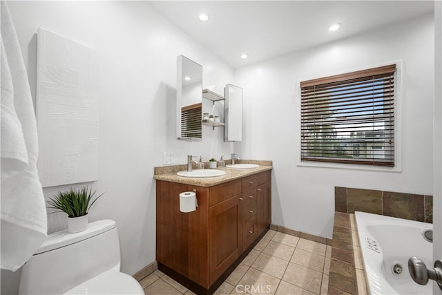 full bath with a bath, toilet, baseboards, and a sink