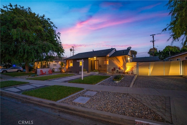 single story home featuring decorative driveway and a yard