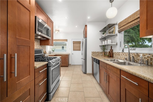 kitchen with decorative backsplash, a wealth of natural light, stainless steel appliances, and a sink