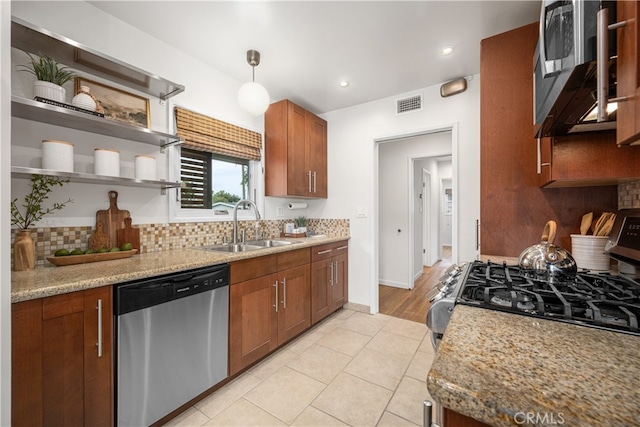 kitchen with stainless steel appliances, visible vents, a sink, and backsplash