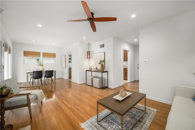 living room featuring a ceiling fan, visible vents, recessed lighting, and light wood-style floors
