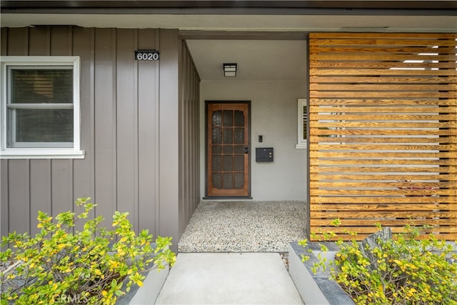 doorway to property with board and batten siding and covered porch