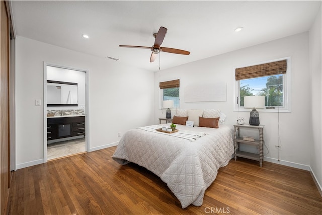 bedroom with baseboards, wood finished floors, visible vents, and recessed lighting