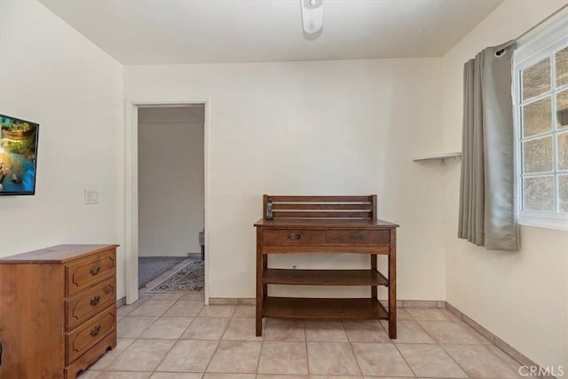interior space featuring baseboards and light tile patterned flooring