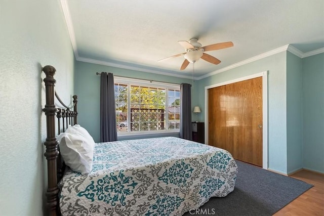 bedroom with baseboards, ornamental molding, a ceiling fan, and wood finished floors