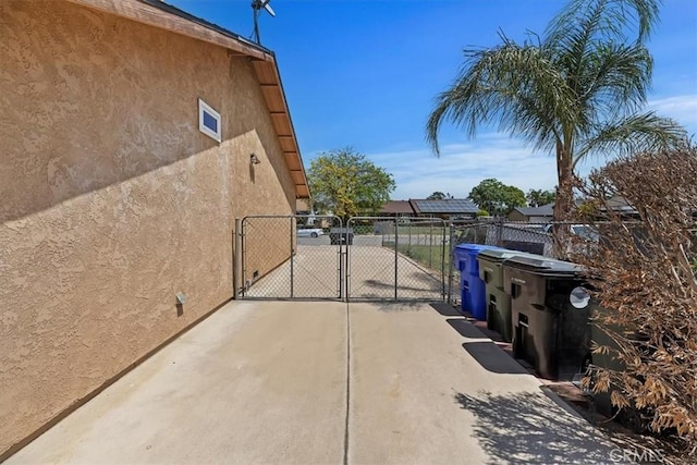 view of patio / terrace featuring a gate, fence, and concrete driveway