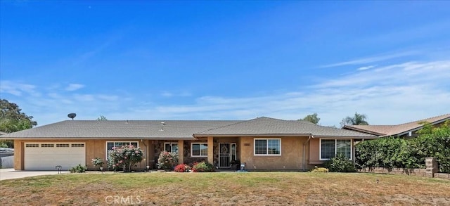 ranch-style home with an attached garage, driveway, a front yard, and stucco siding