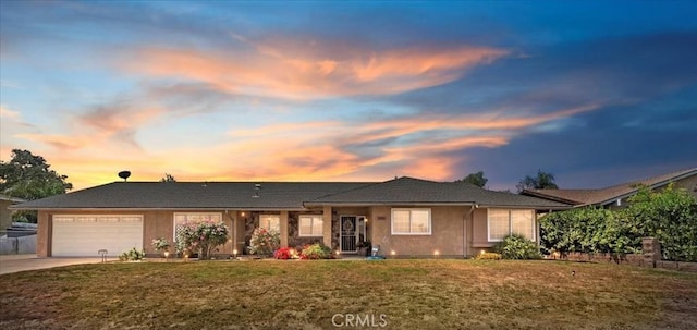 view of front of property with a garage, stucco siding, a yard, and concrete driveway
