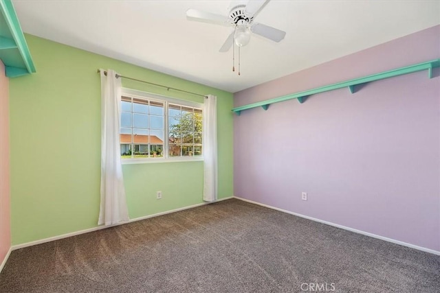 spare room featuring carpet flooring, a ceiling fan, and baseboards