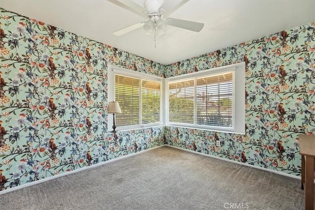 carpeted spare room with a healthy amount of sunlight, baseboards, and wallpapered walls