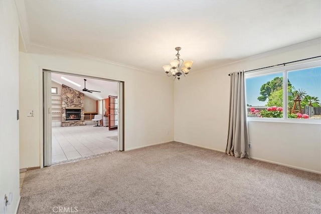 unfurnished room featuring crown molding, a fireplace, carpet, ceiling fan with notable chandelier, and vaulted ceiling