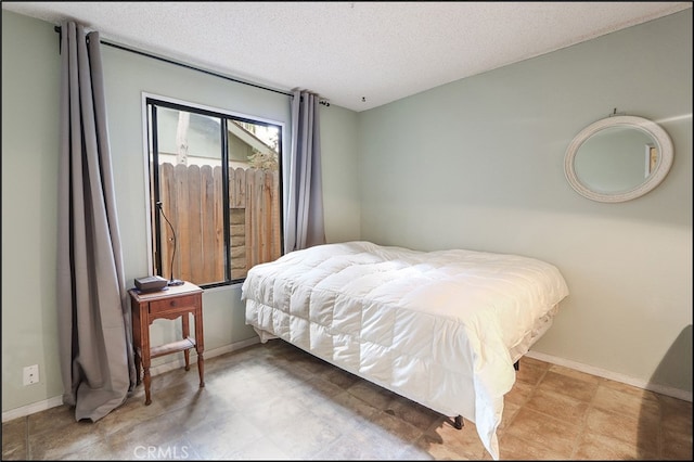 bedroom featuring a textured ceiling and baseboards