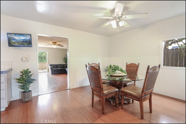 dining room featuring wainscoting, ceiling fan, and light wood-style floors