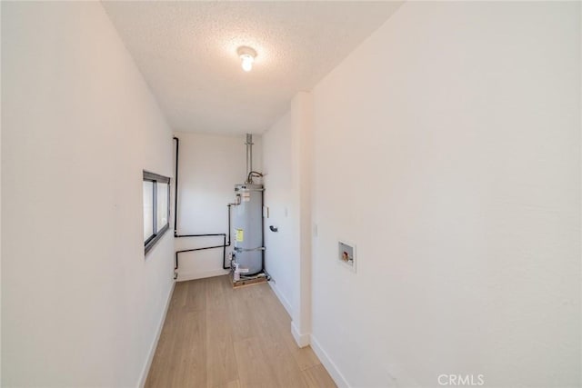 932 S Bon View Ave, Ontario, CA 91761 - corridor featuring strapped water heater, light wood-style flooring, and a textured ceiling