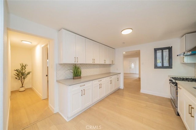 932 S Bon View Ave, Ontario, CA 91761 - kitchen featuring gas range, light countertops, decorative backsplash, and light wood-type flooring