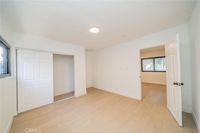 932 S Bon View Ave, Ontario, CA 91761 - unfurnished bedroom featuring light wood-type flooring, a closet, and a textured ceiling
