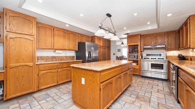 18668 Lemert St, Hesperia, CA 92345 - kitchen featuring stone finish floor, a kitchen island, under cabinet range hood, stainless steel appliances, and a raised ceiling