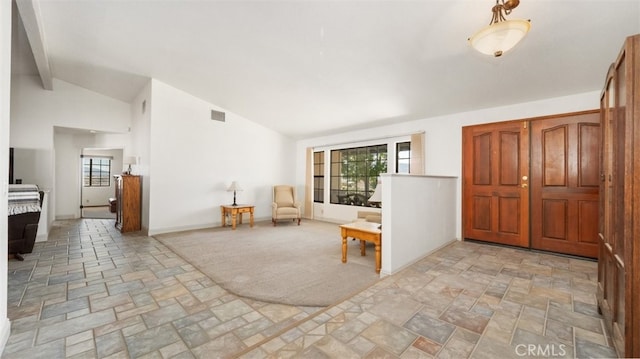 18668 Lemert St, Hesperia, CA 92345 - foyer featuring visible vents, stone finish floor, lofted ceiling with beams, and a healthy amount of sunlight