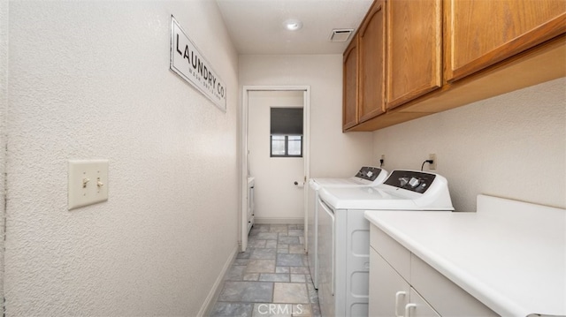 18668 Lemert St, Hesperia, CA 92345 - laundry area featuring separate washer and dryer, baseboards, visible vents, cabinet space, and stone finish flooring