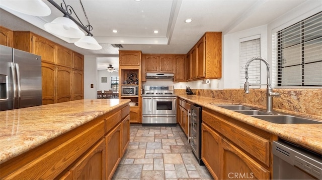 18668 Lemert St, Hesperia, CA 92345 - kitchen with a sink, appliances with stainless steel finishes, under cabinet range hood, brown cabinetry, and stone tile floors
