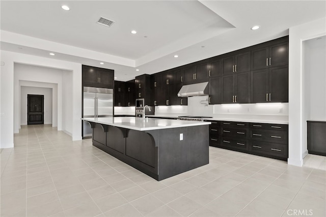 kitchen with recessed lighting, under cabinet range hood, light countertops, visible vents, and appliances with stainless steel finishes