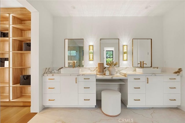 bathroom with marble look tile flooring and vanity