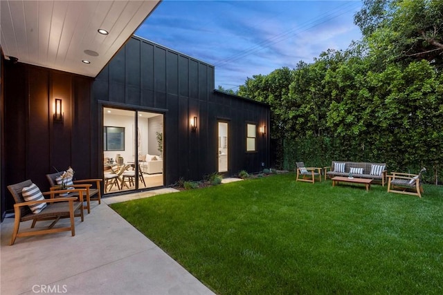 view of grassy yard featuring an outdoor living space and a patio area