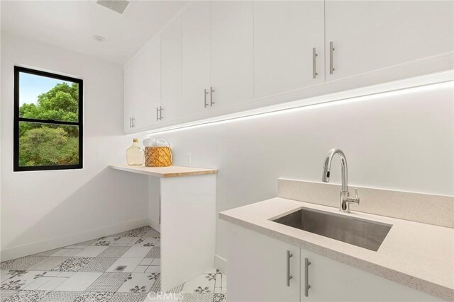 laundry room featuring a sink and baseboards