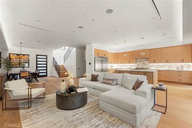 living room with light wood finished floors and stairway