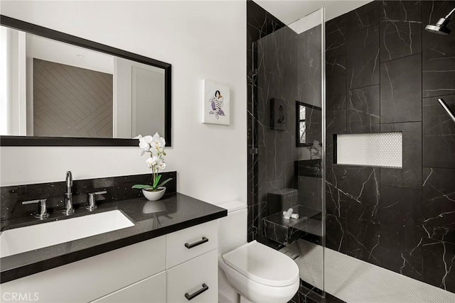 bathroom with vanity, a marble finish shower, and toilet