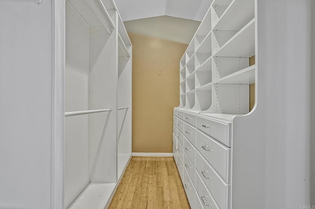 spacious closet featuring lofted ceiling and light wood-type flooring