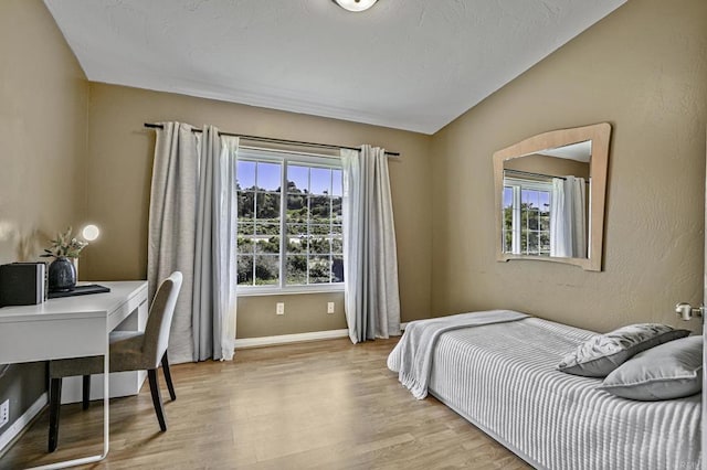 bedroom with light wood-style flooring and baseboards