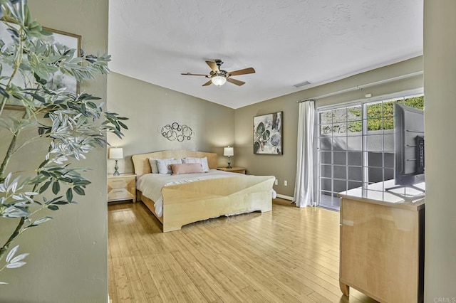 bedroom featuring wood finished floors, ceiling fan, baseboards, access to exterior, and visible vents
