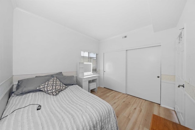 640 Camino De La Reina Unit 1309, San Diego, CA 92108 - bedroom featuring crown molding, visible vents, light wood-style flooring, and a closet