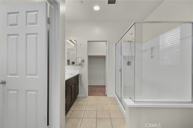 full bathroom with tile patterned flooring, a stall shower, and vanity