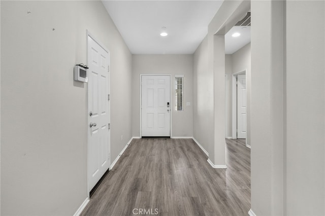 doorway to outside with baseboards and wood finished floors