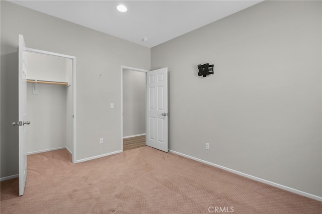 unfurnished bedroom with a closet, baseboards, recessed lighting, and light colored carpet