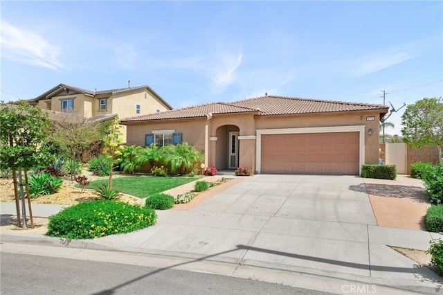 mediterranean / spanish-style home with an attached garage, a tiled roof, concrete driveway, and stucco siding