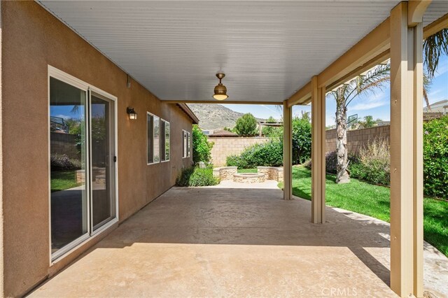 view of patio with a mountain view and fence