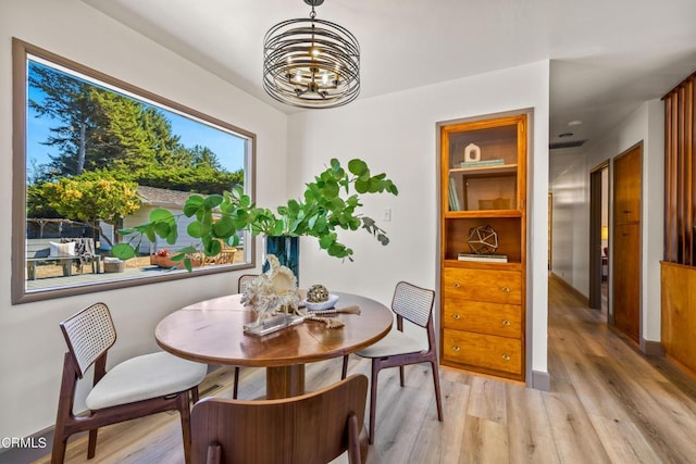 dining area with a notable chandelier and light wood-style floors