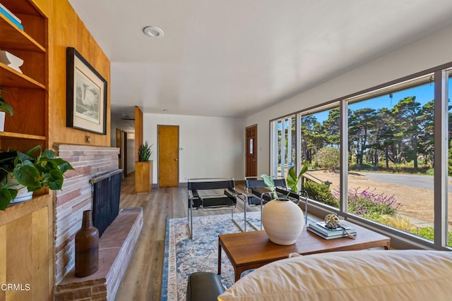 living room featuring wood finished floors and a brick fireplace