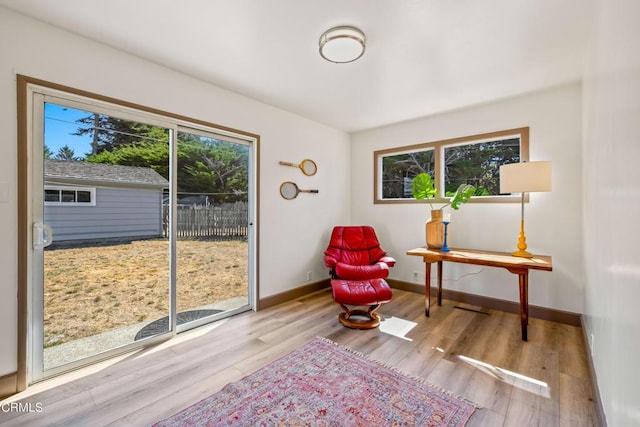 sitting room featuring baseboards, wood finished floors, and plenty of natural light