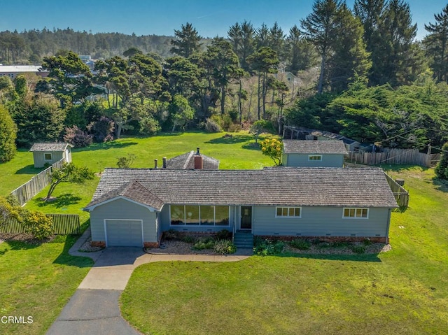 view of front facade with a front yard, driveway, a garage, and fence